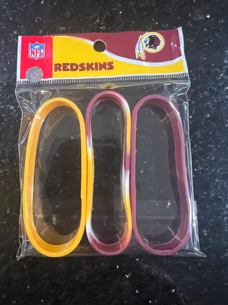 The Washington Redskins Adult Mylar NFL Team Logo + Color 3pk Wristbands Bracelet is a set of three wristbands featuring the iconic team logo and colors of the Washington Commanders.