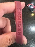 The Washington Redskins Adult Mylar NFL Team Logo + Color 3pk Wristbands Bracelet is a set of three wristbands featuring the iconic team logo and colors of the Washington Commanders.