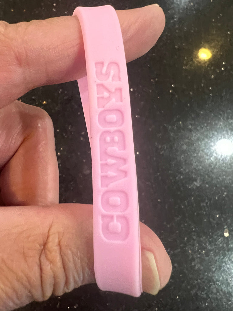 Dallas Cowboys NFL Team Logo Adult Women's Pink Wristband Mylar Bracelet is a stylish and feminine accessory for female fans of the iconic football team.